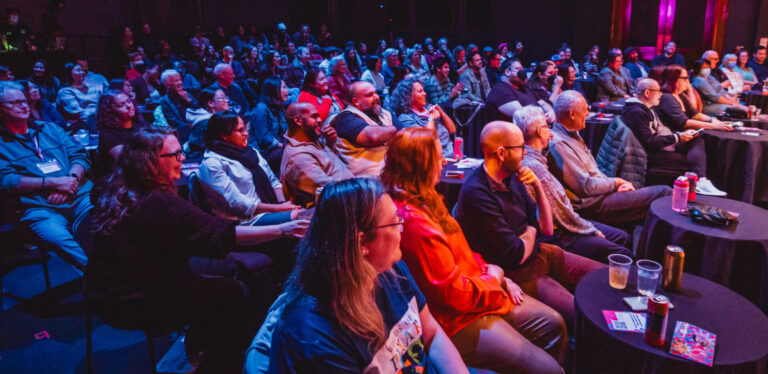 The franco boni theatre is packed with audience members having a drink and ready to enjoy the show!