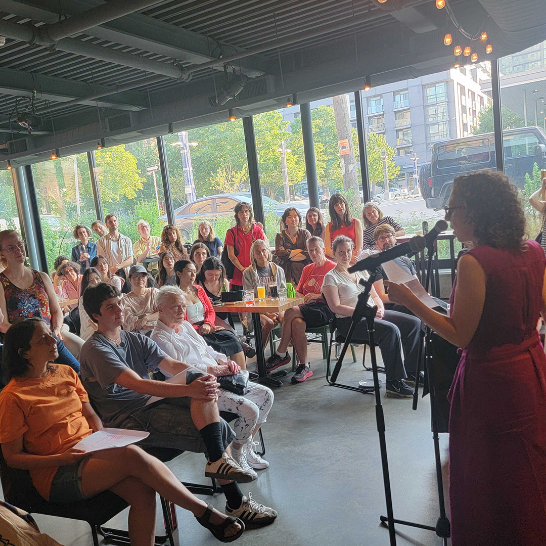 around 60 people gather in the cafe to listen to a reading from Ronna Bloom